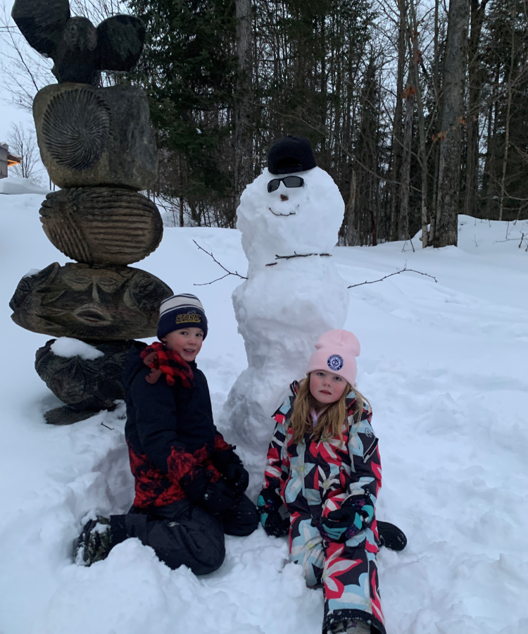 1 kids in front of a snowman